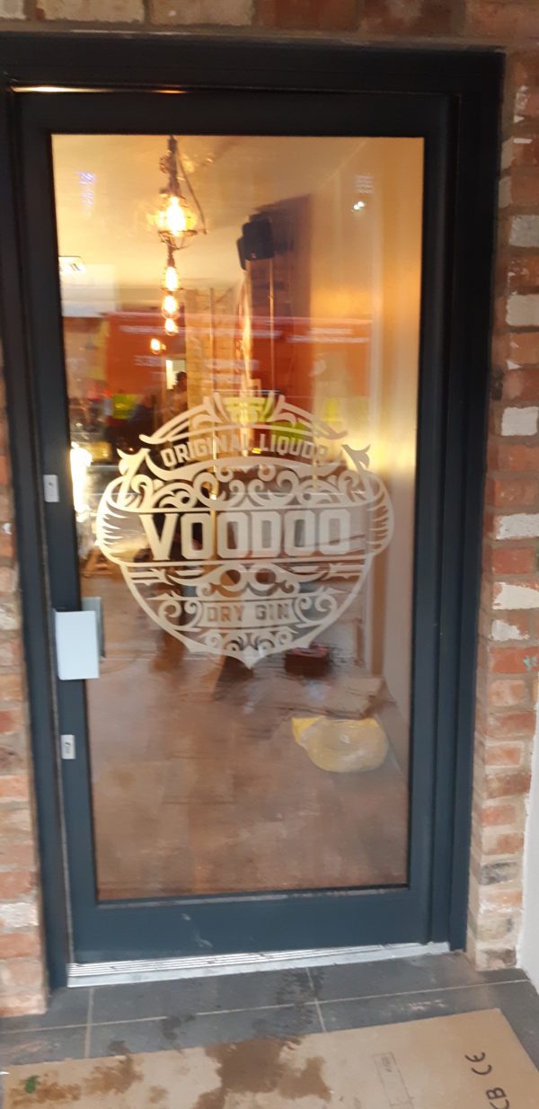 Cut vinyl Voodoo Dry Gin logo applied to a glass entrance door