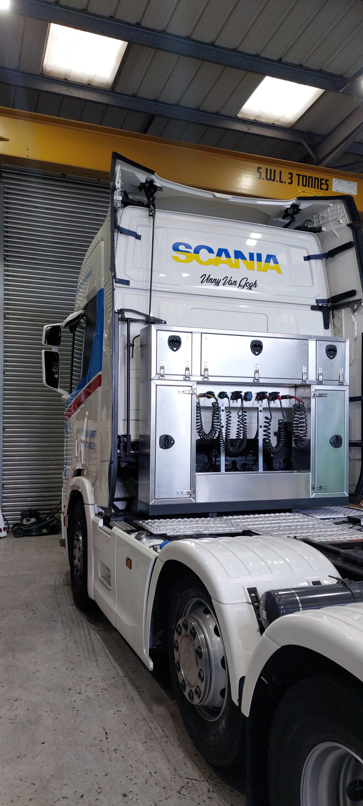 Scania tractor unit with fitted vehicle graphics in the workshop