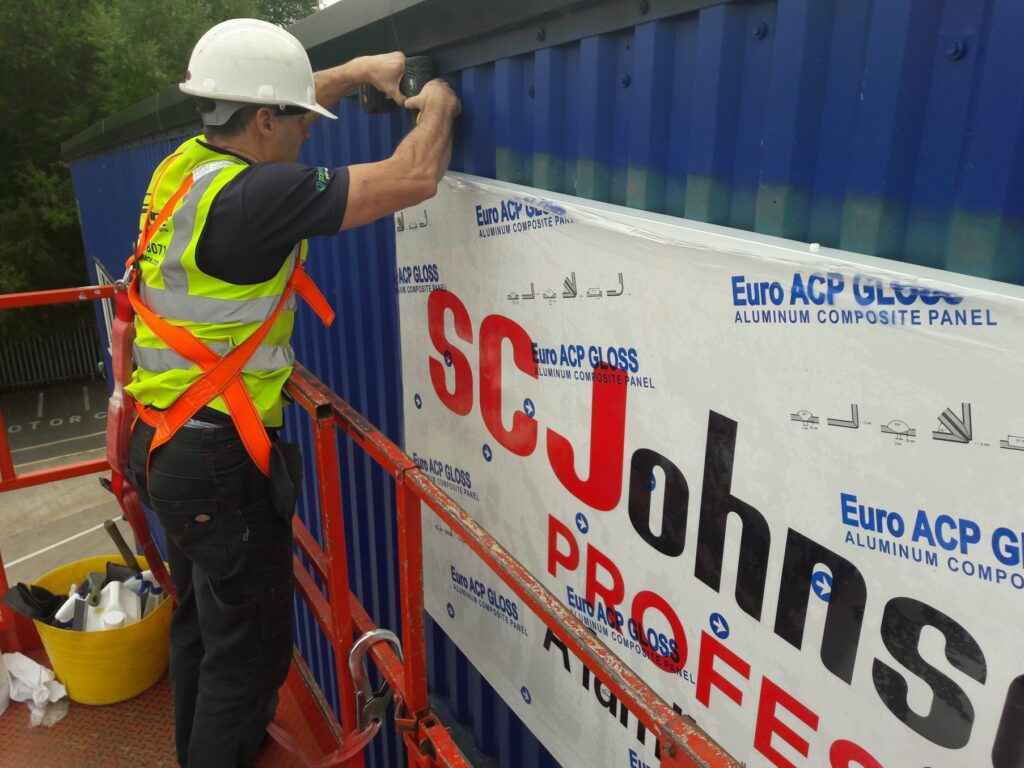 Printscene team installing a large exterior business sign