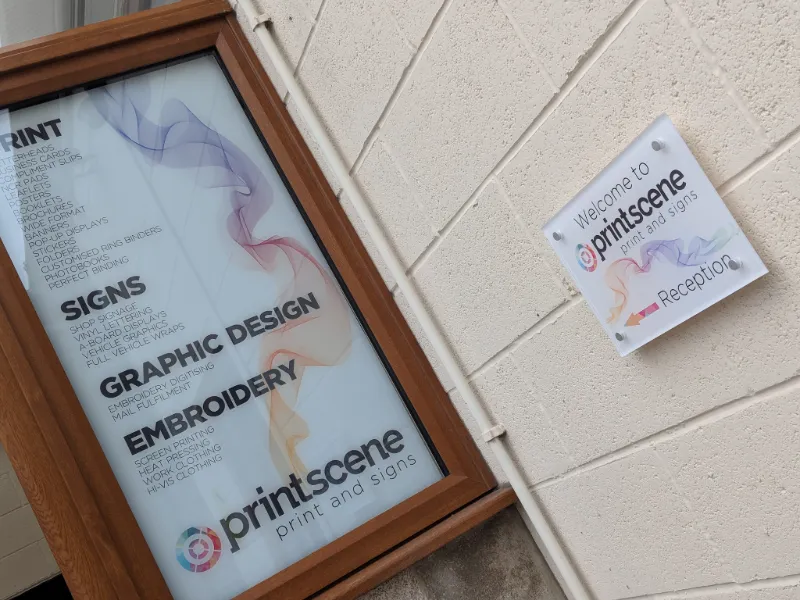 Printscene services board by the reception door listing letterheads, business cards, compliment slips, NCR pads and folders under Print